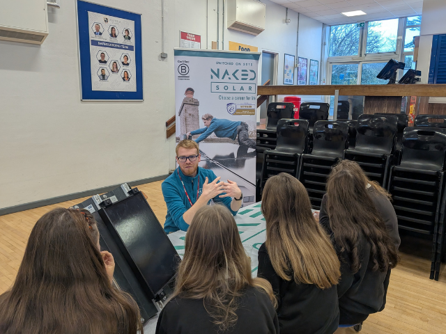 A Naked Solar team member talking to students about solar careers at a school careers fair